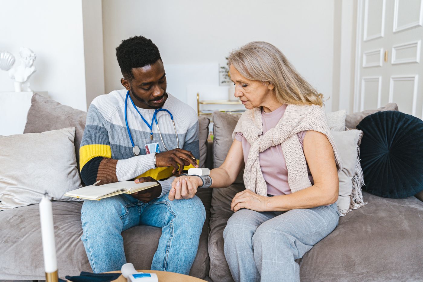 A registered nurse checking in with a senior client at home